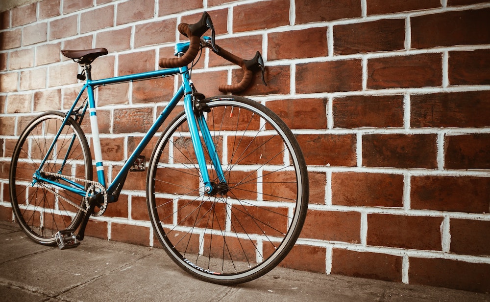 Blue bike against a brick wall